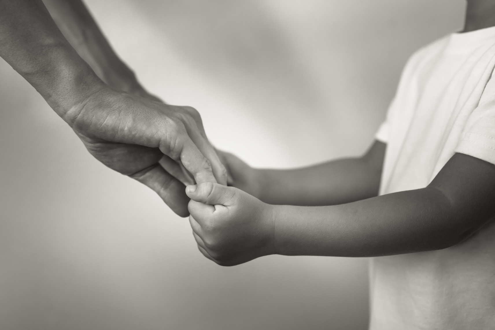 Mother holding child's hands.